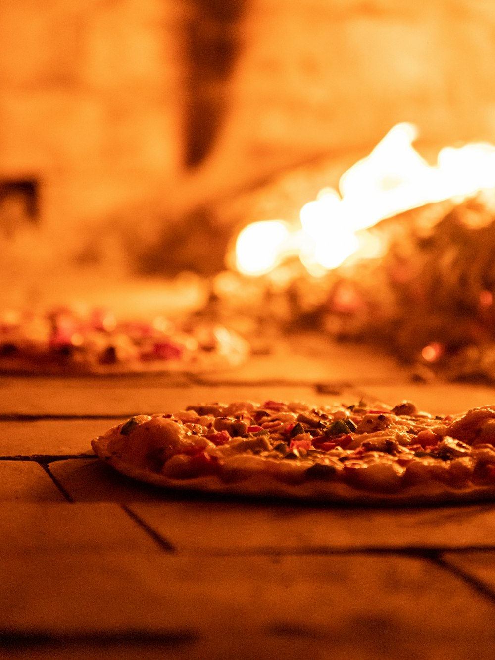 una pizza seduta sul pavimento davanti a un fuoco