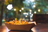 Modern cardboard trays holding appetizing food in a bright café setting.