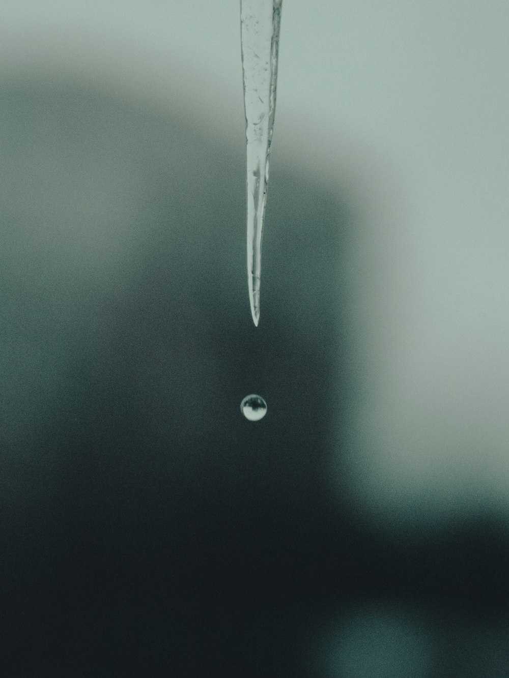 a drop of water hanging from a faucet