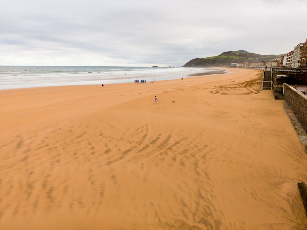 a sandy beach next to a body of water