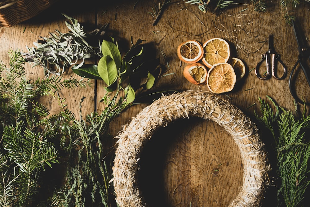 a wooden table topped with oranges and herbs