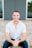 a man sitting on the ground in front of a door