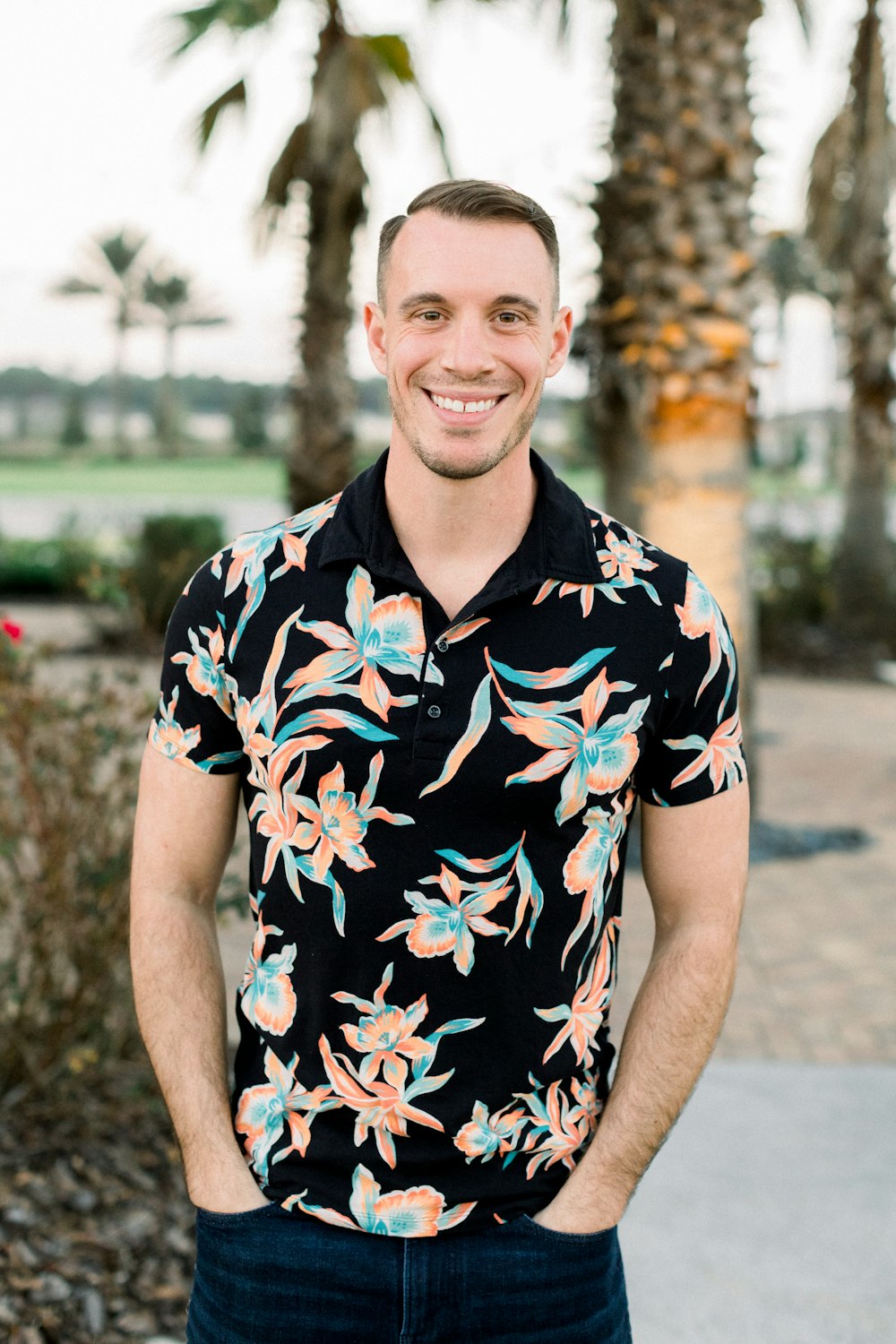 a man standing in front of a palm tree