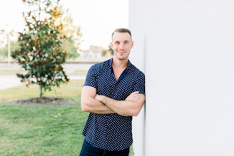 a man leaning against a wall with his arms crossed