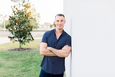 photography poses for men,how to photograph alex sanfilippo, the founder of podpros, confidently leaning against a wall with arms crossed out on the lawn. model alex sanfilippo, the founder of podpros @ podpros.com; a man leaning against a wall with his arms crossed