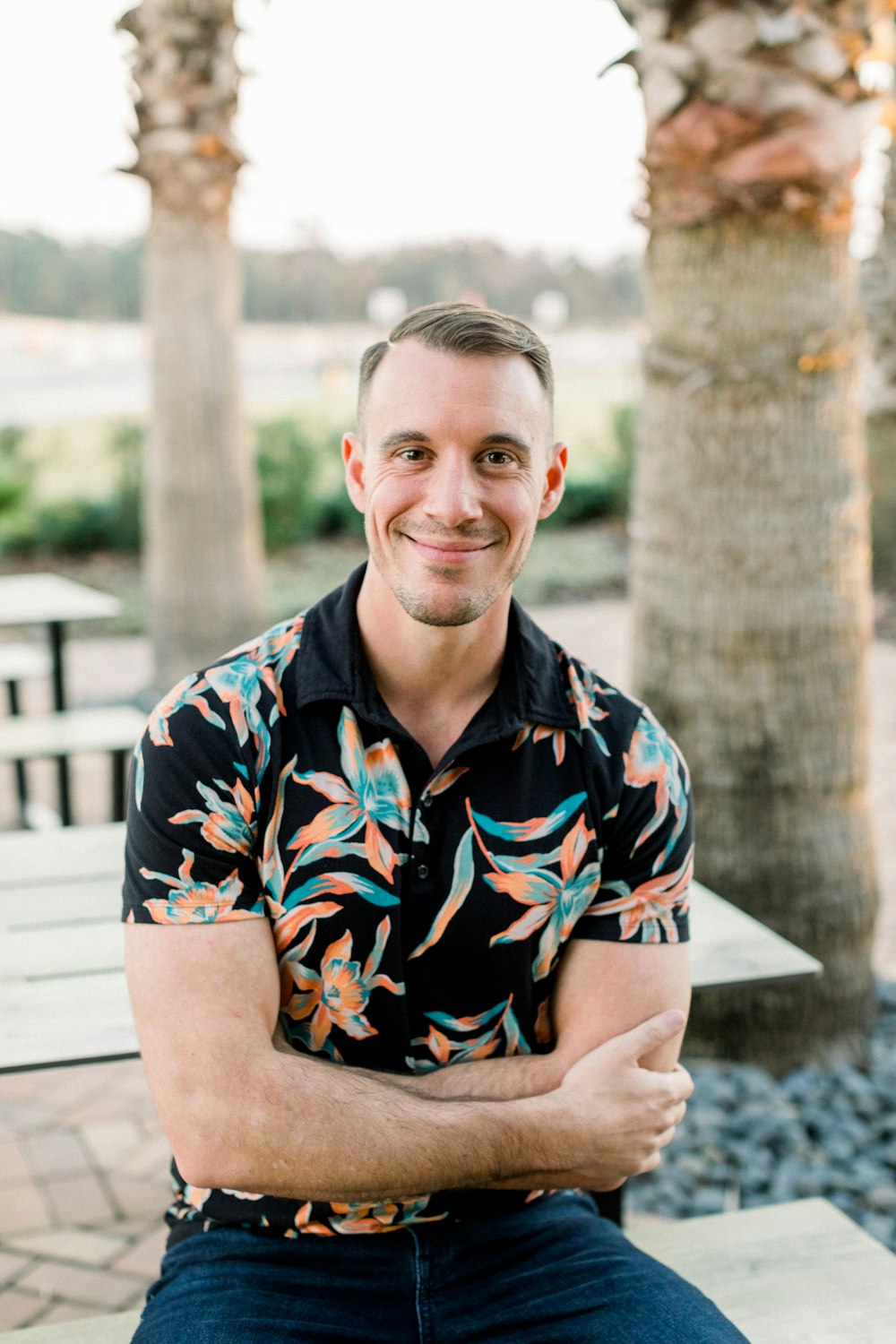 a man sitting on a bench in front of palm trees