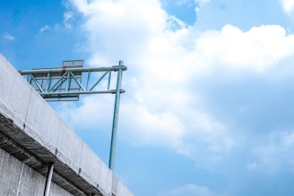 A sturdy gantry board installed over a busy national highway under clear skies.