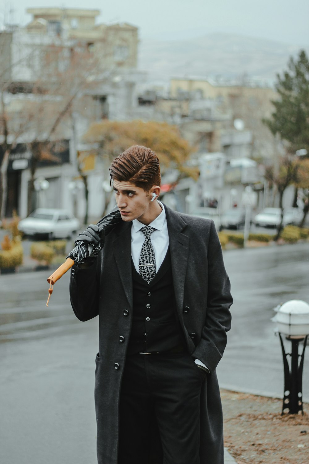 a man in a suit and tie holding an umbrella