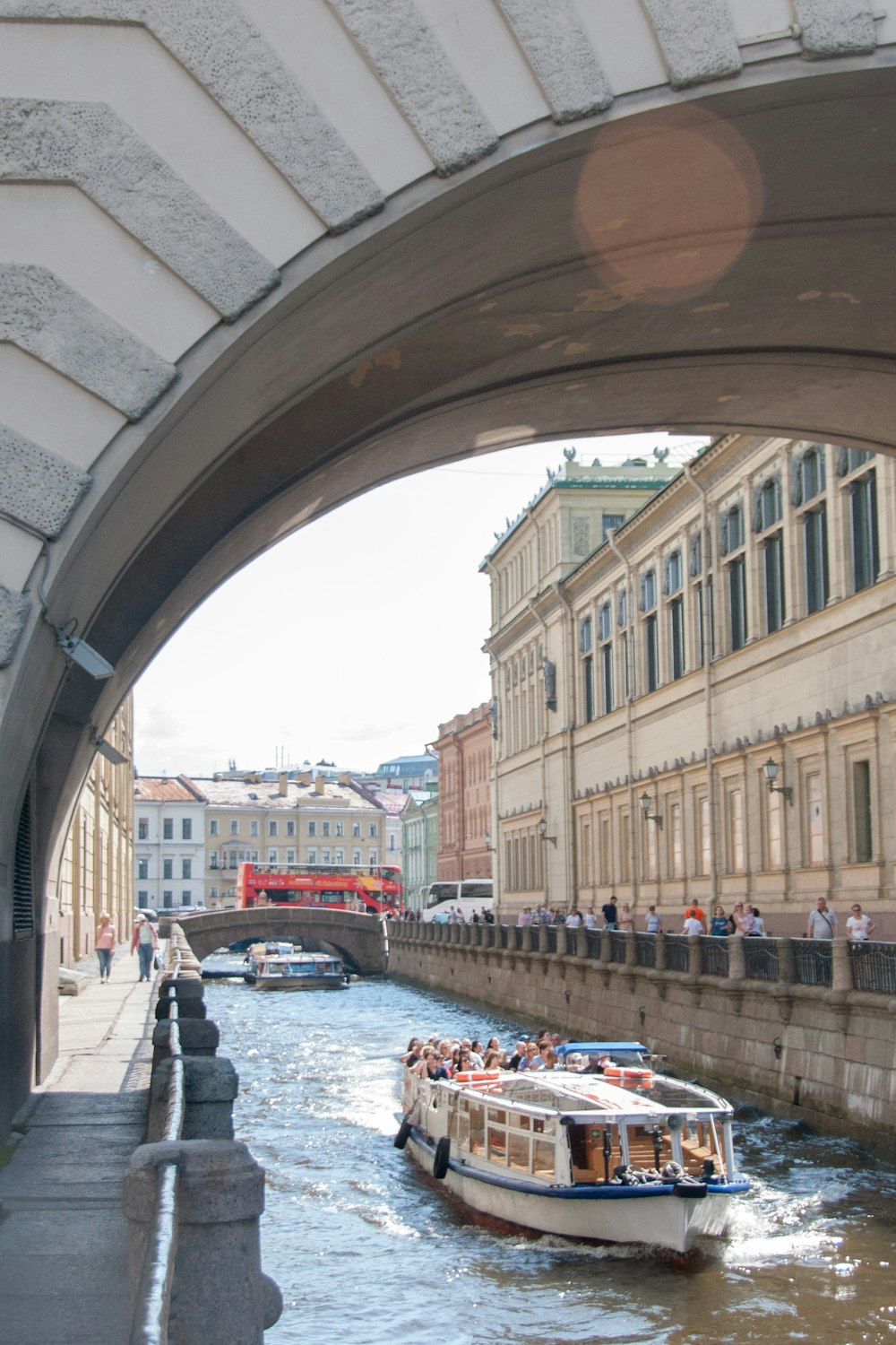 a boat traveling down a river under a bridge