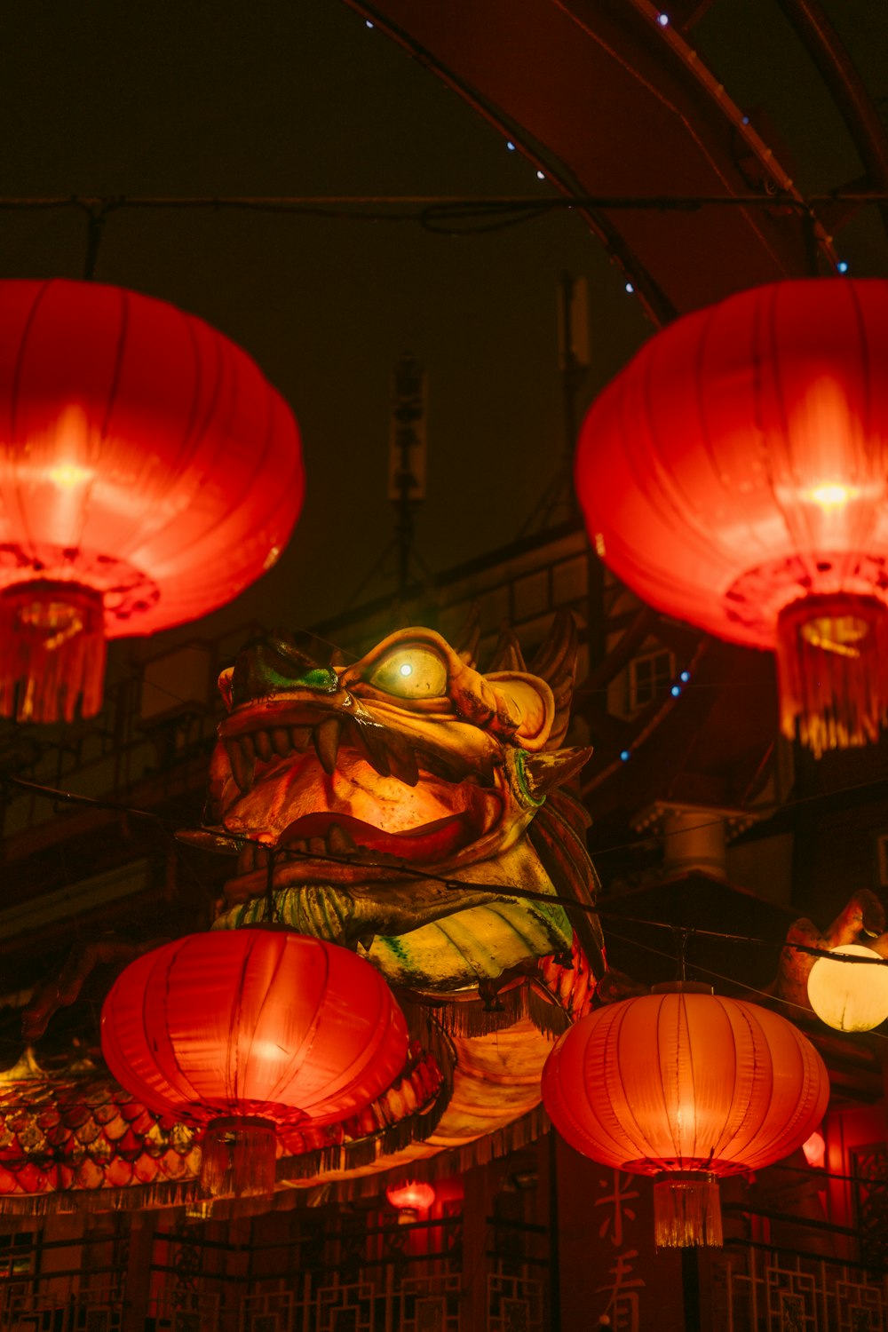 a dragon statue surrounded by red lanterns at night