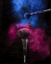 a purple and blue powdered makeup brush on a black background