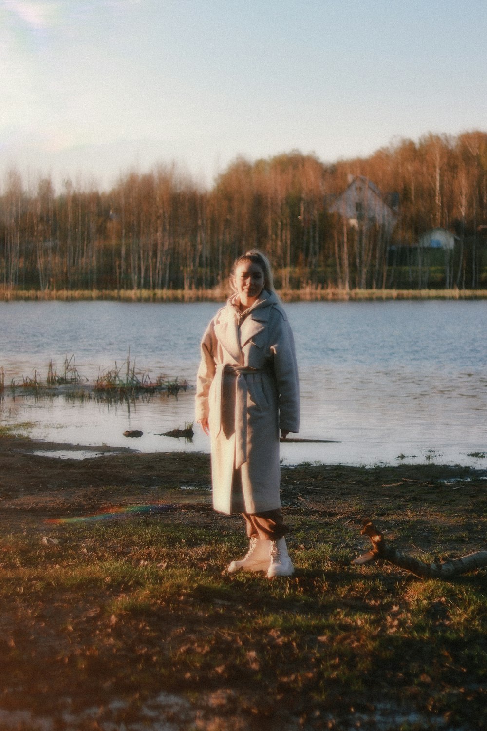 a woman standing in front of a body of water