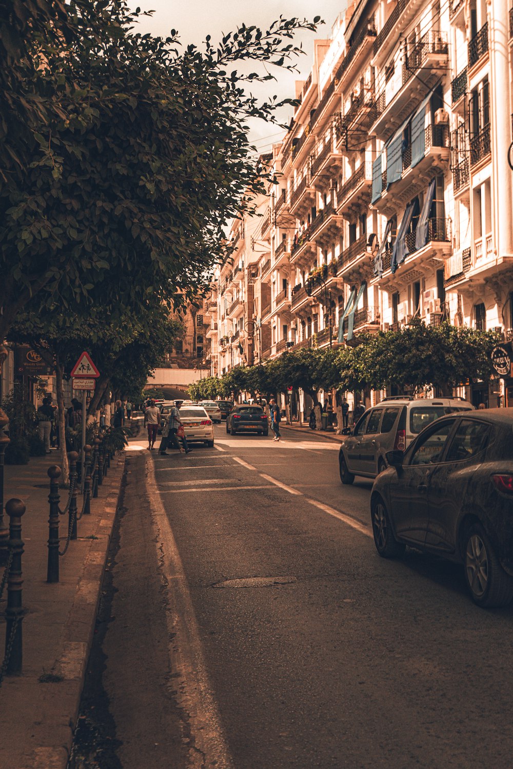 a city street lined with tall buildings and parked cars