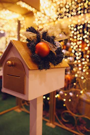 a birdhouse with a christmas decoration on top of it