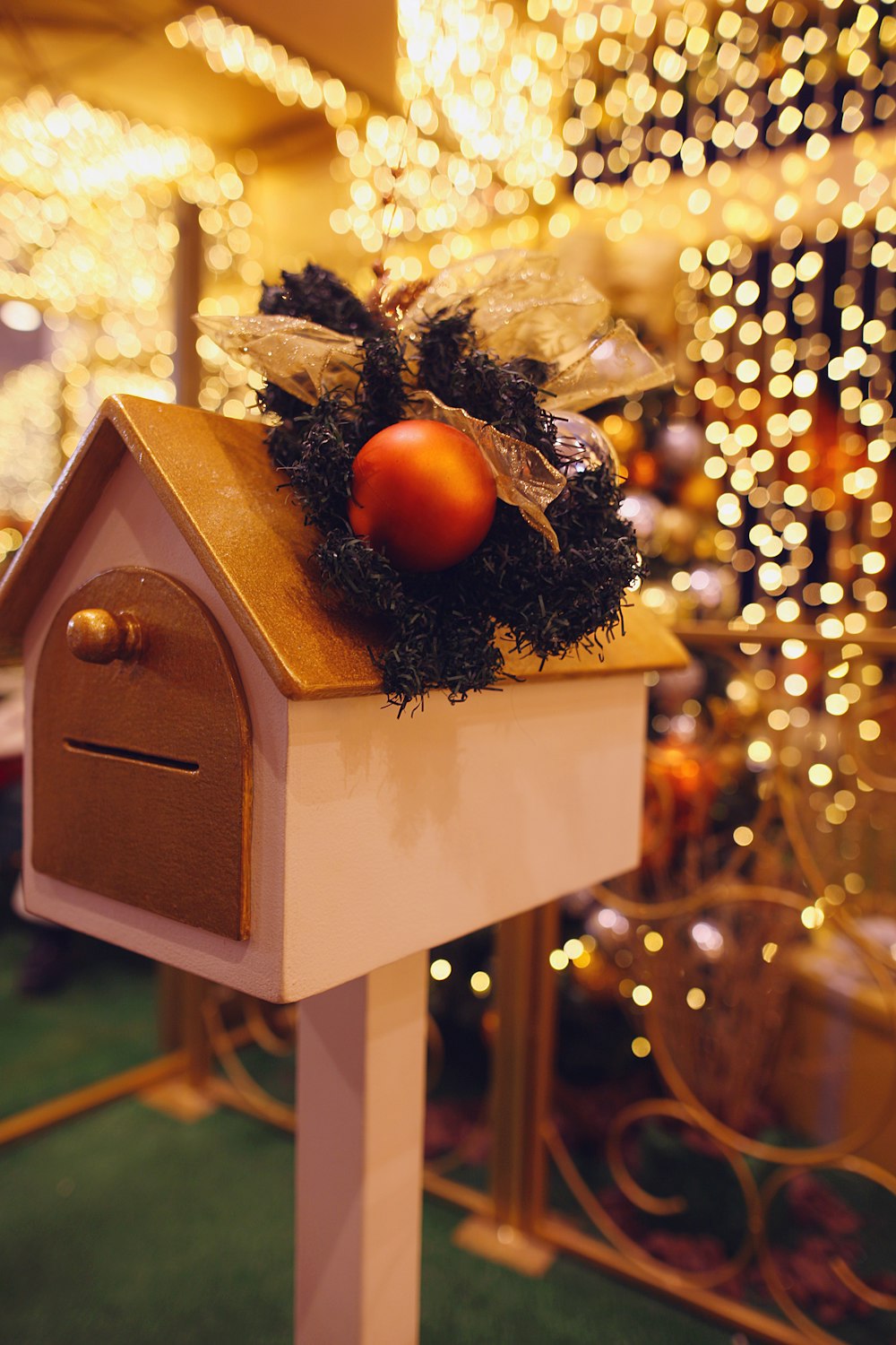 a birdhouse with a christmas decoration on top of it