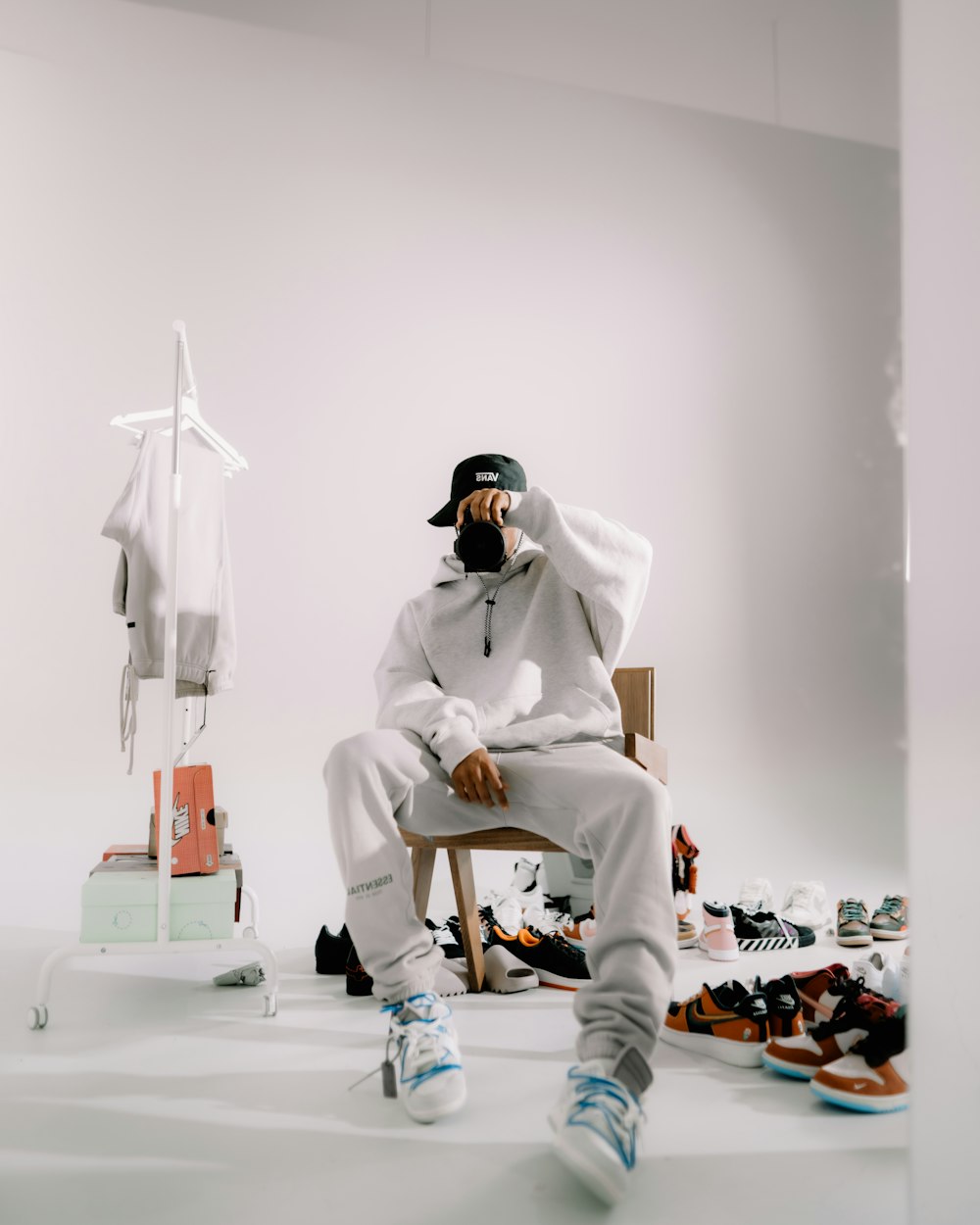 a man sitting in a chair in front of a pile of shoes