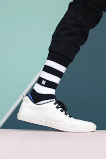 a person wearing black and white striped socks