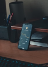 a cell phone sitting on top of a wooden desk