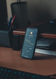 a cell phone sitting on top of a wooden desk
