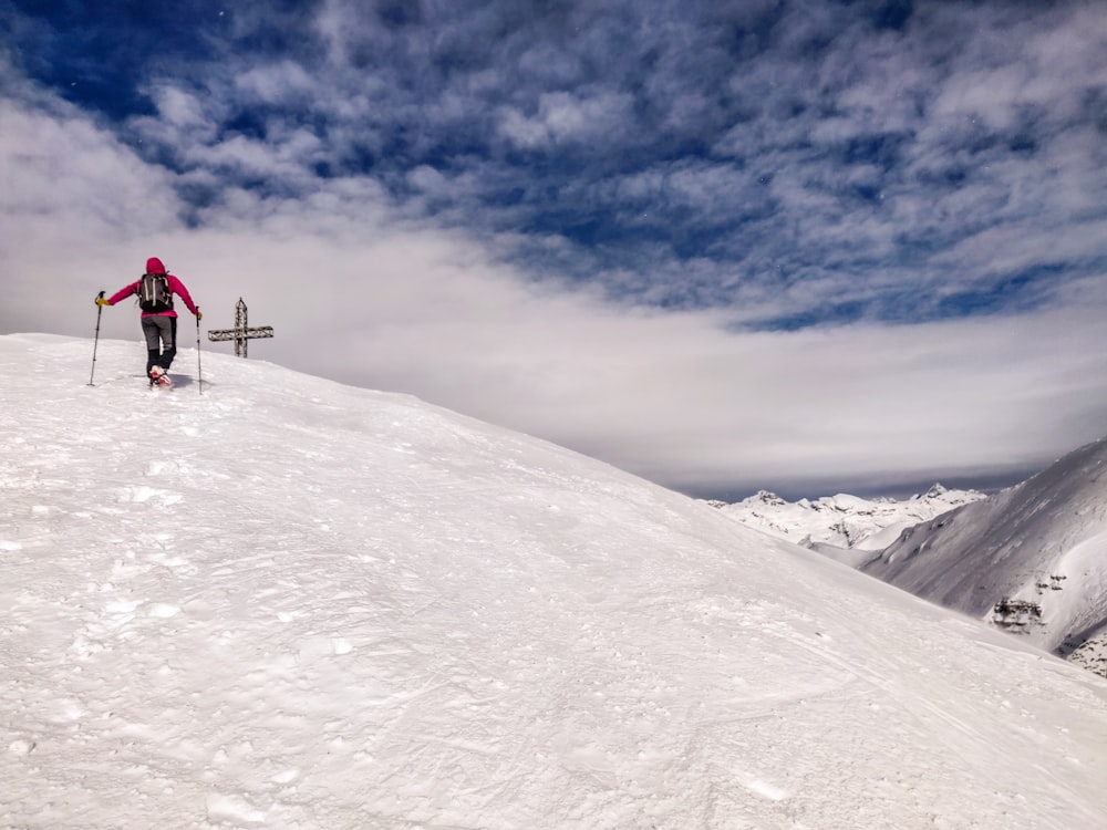 a man riding skis down the side of a snow covered slope