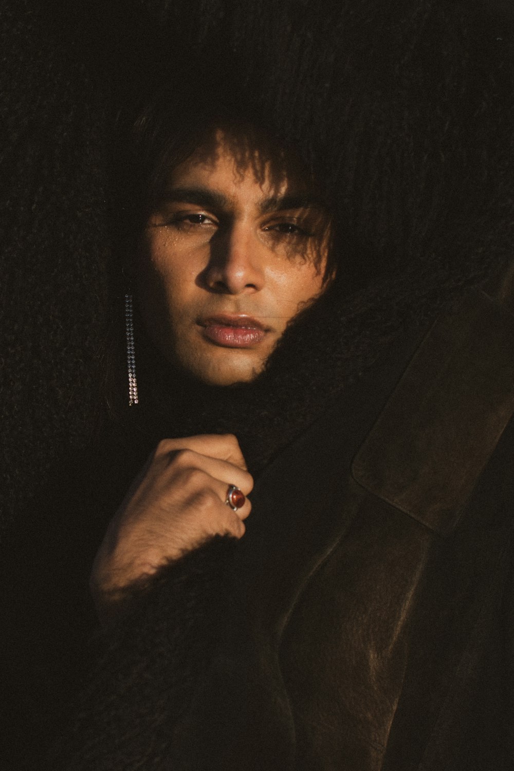 a man in a fur coat with a ring on his finger