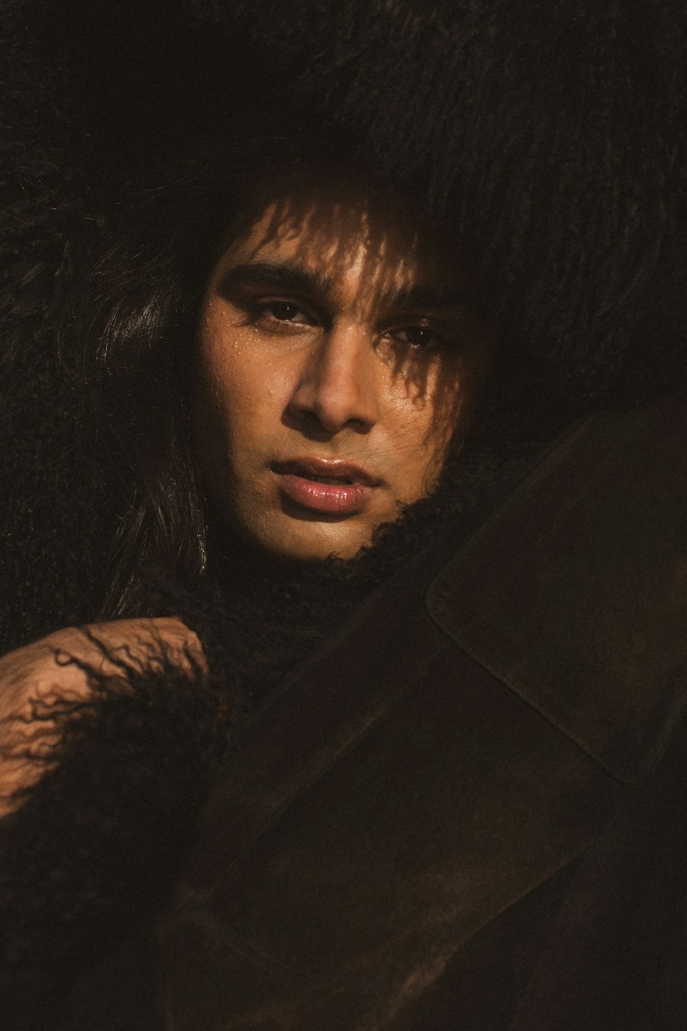 a man with long hair wearing a fur hat