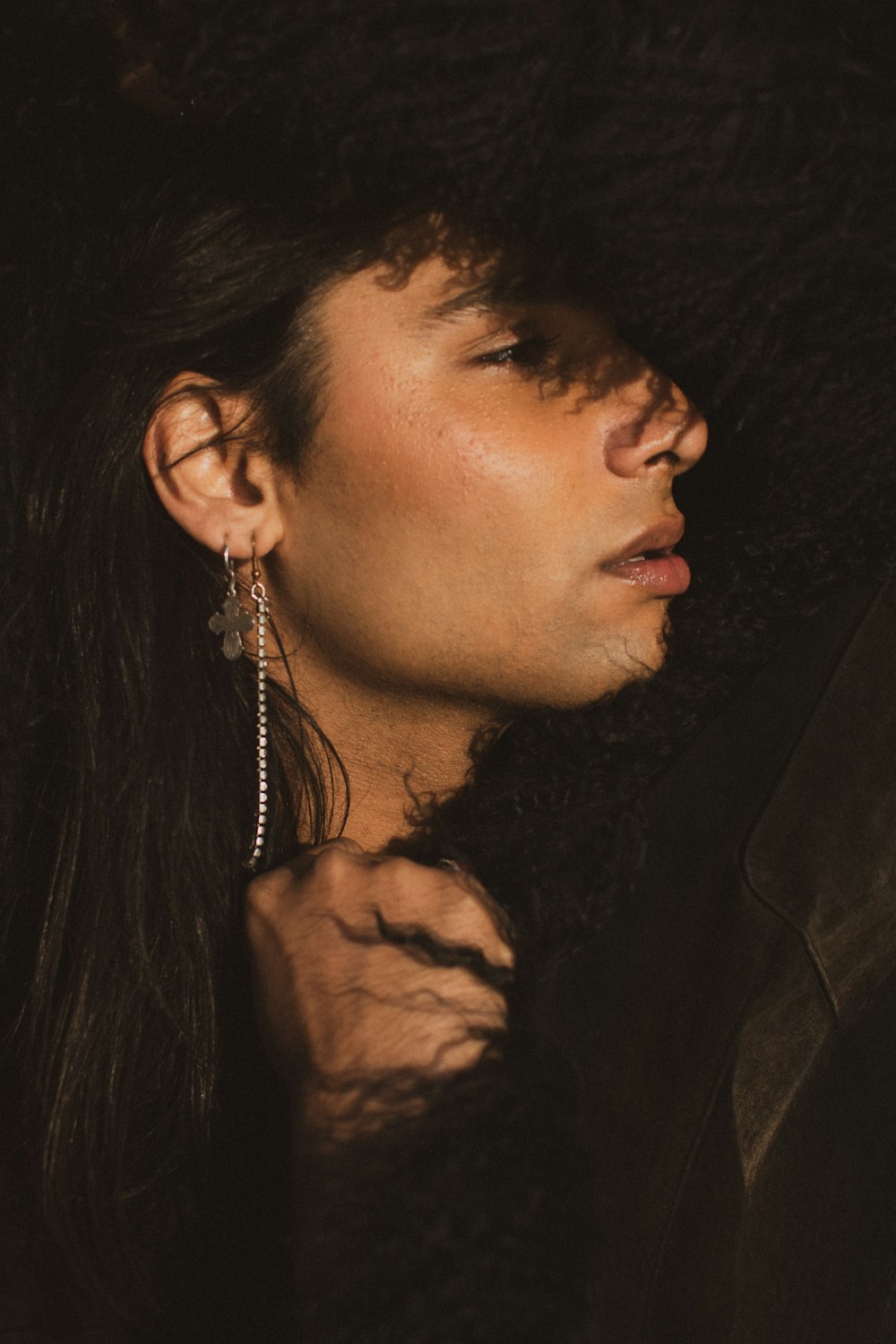 a woman with long black hair wearing earrings