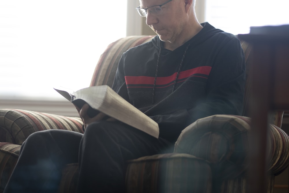a man sitting in a chair reading a book