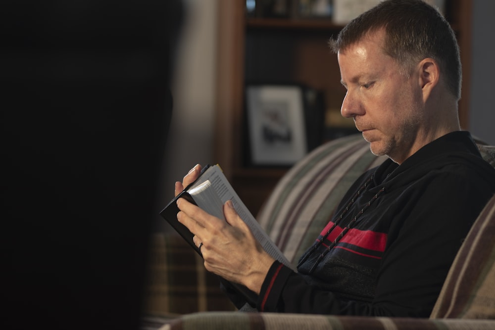 a man sitting in a chair reading a book