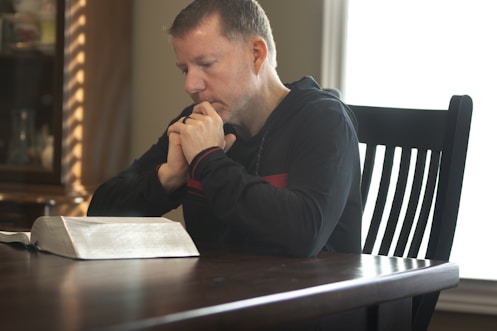 a man sitting at a table with a book in front of him