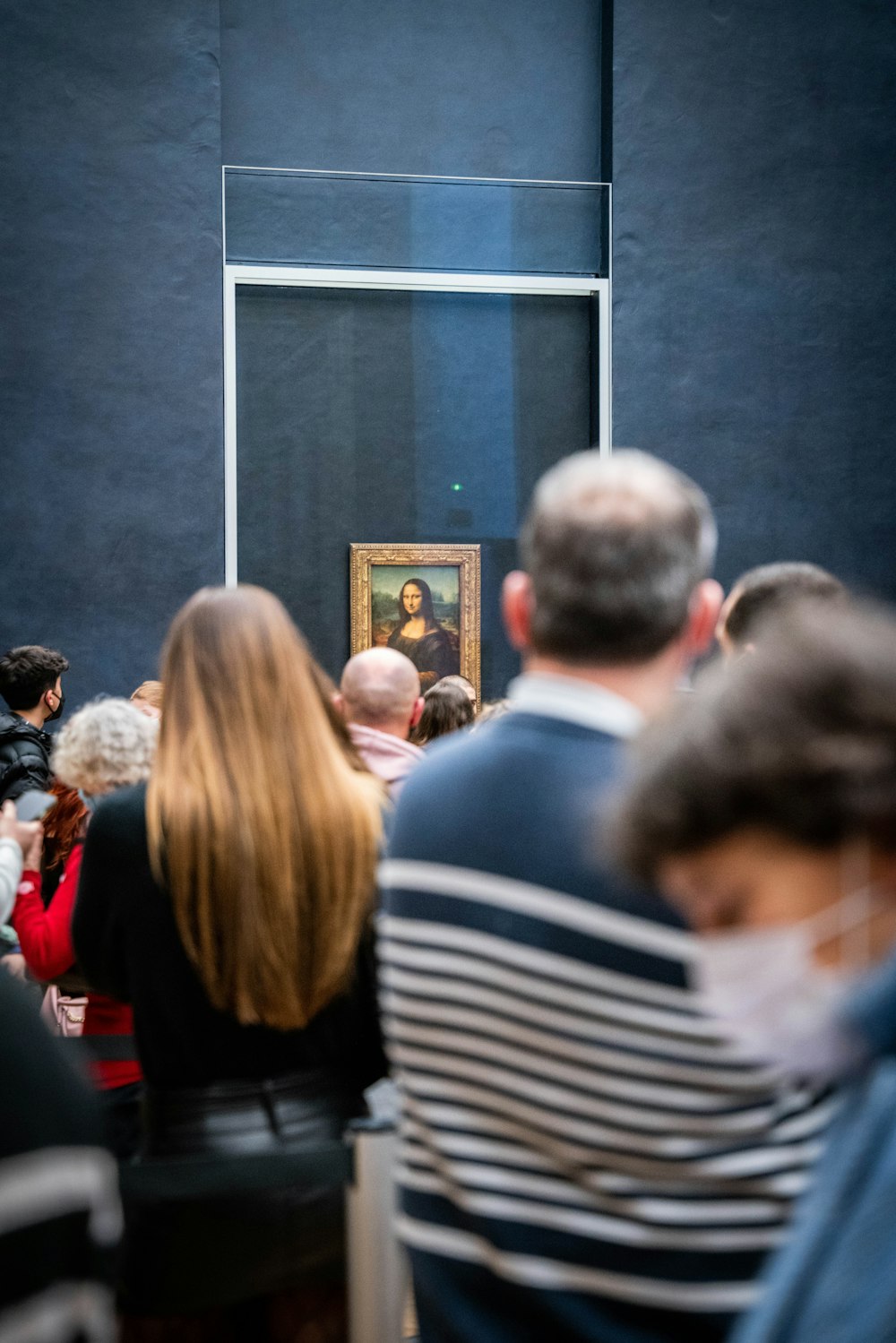 a group of people standing in front of a painting