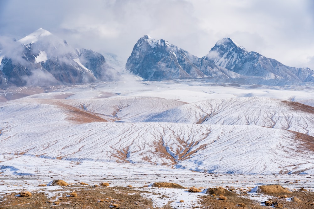 a mountain range covered in snow and clouds