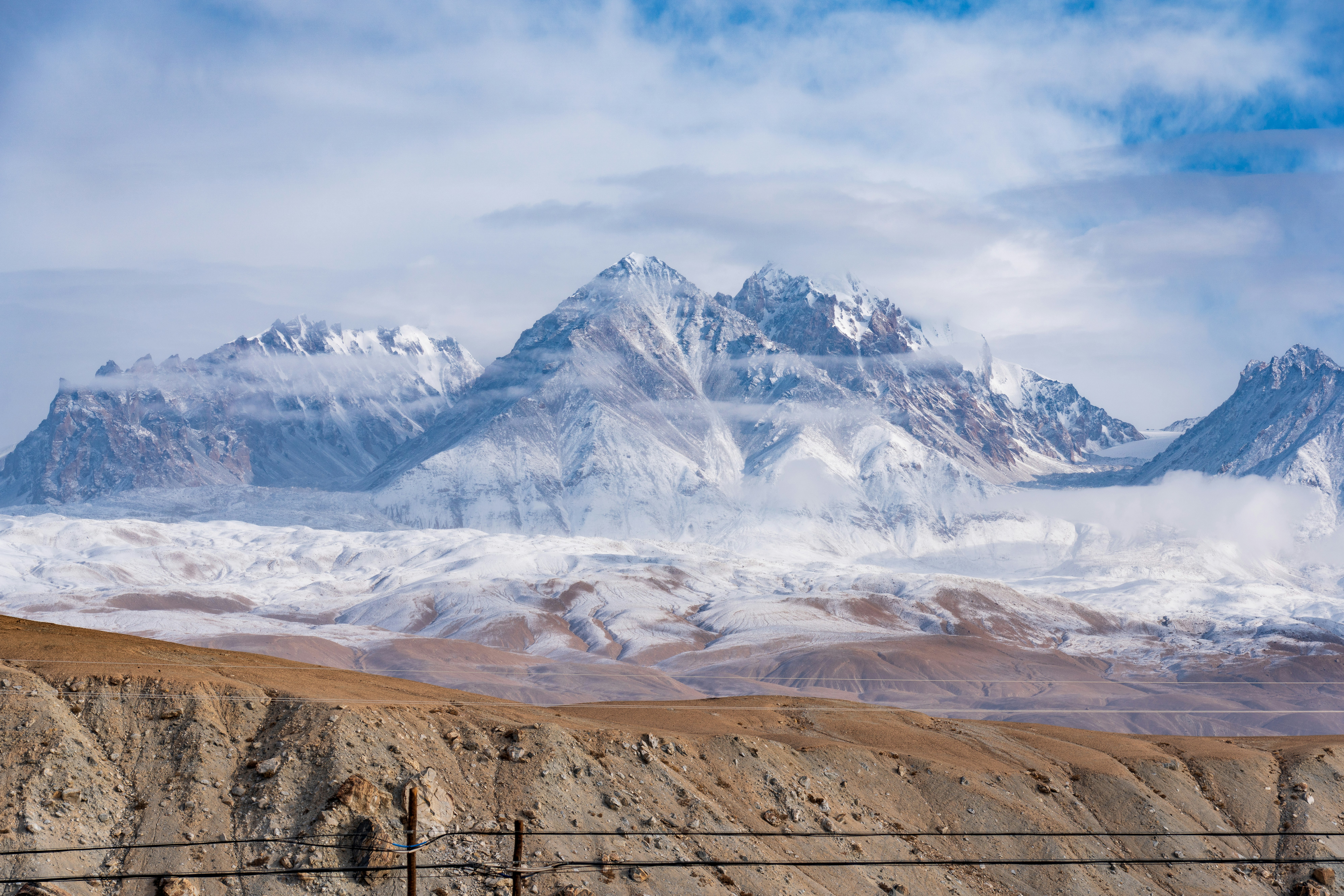a mountain range covered in snow and clouds