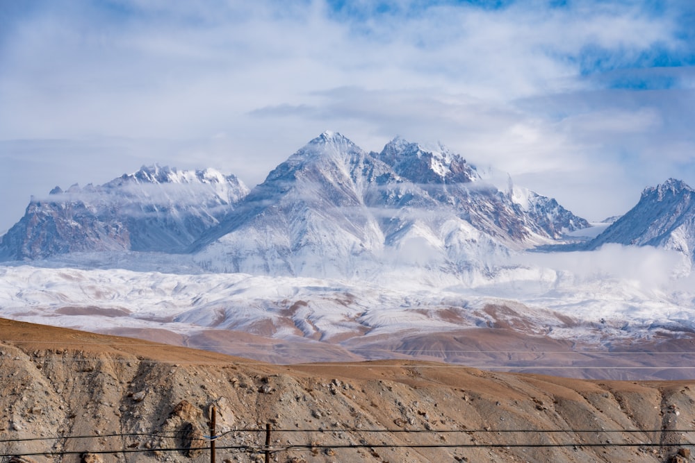 a mountain range covered in snow and clouds