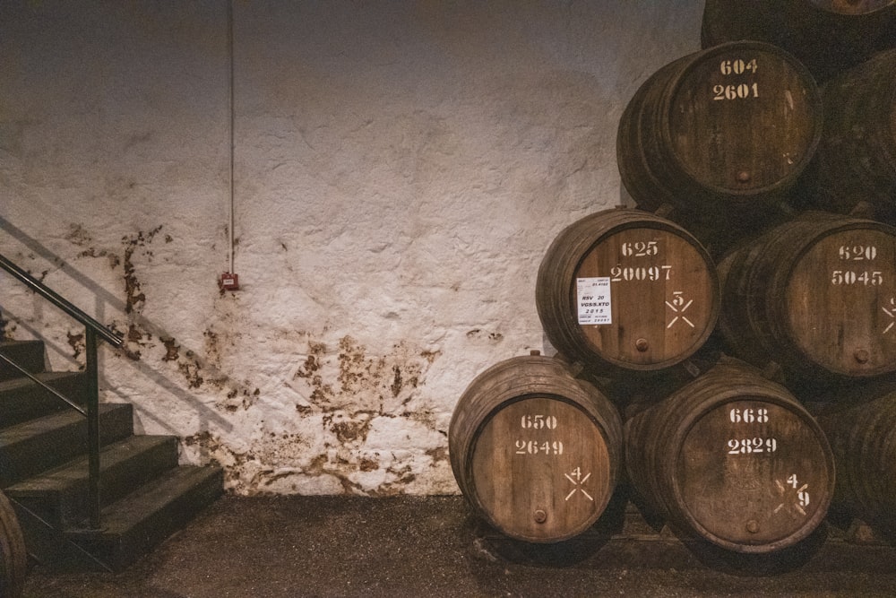 a bunch of wine barrels stacked up against a wall