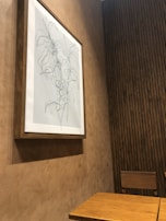 A cozy corner with a minimalist framed print hanging above a small plant.