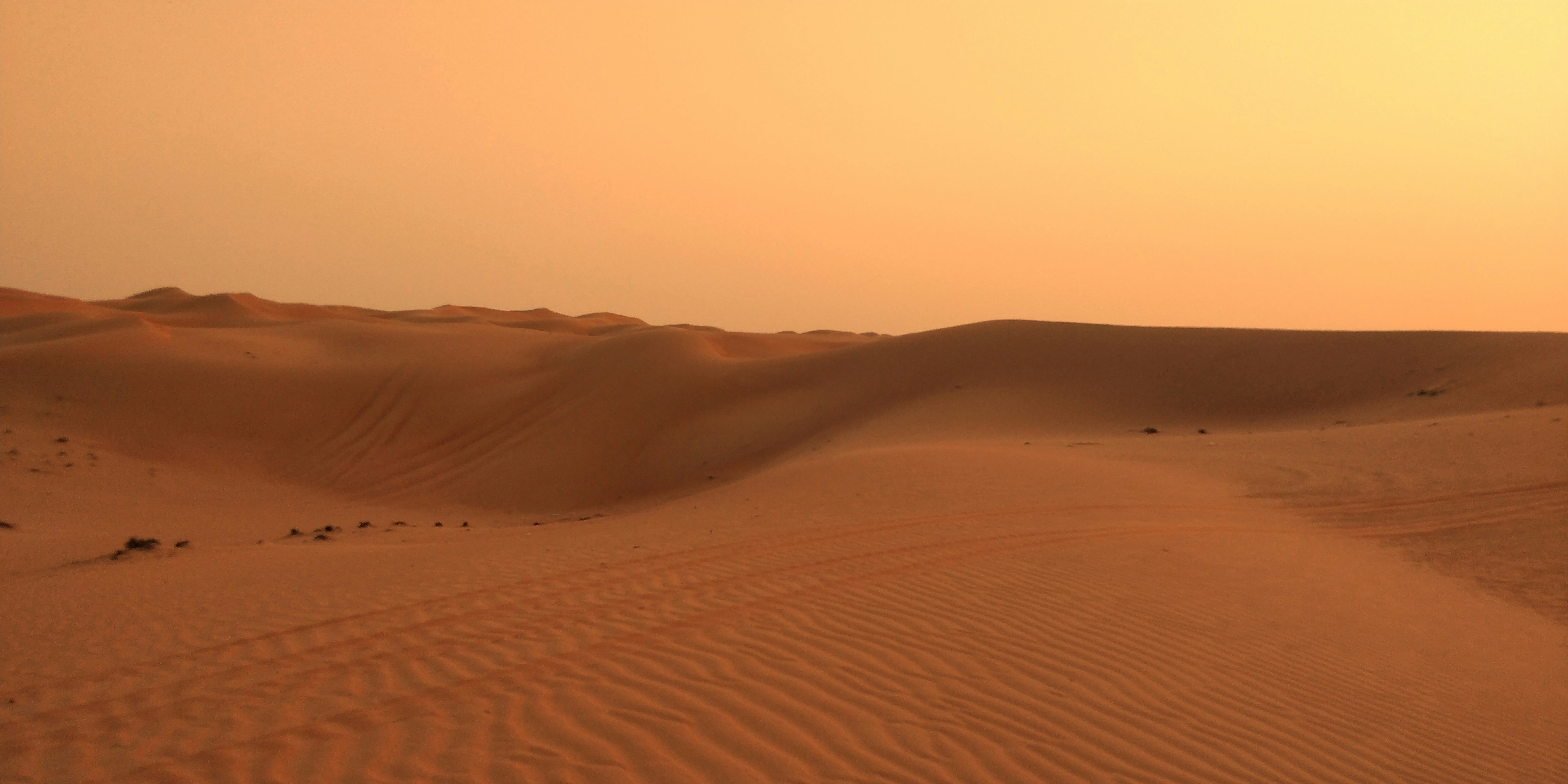 the sun is setting over the sand dunes