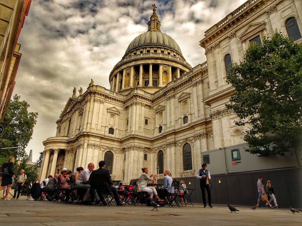 a group of people sitting at tables in front of a building