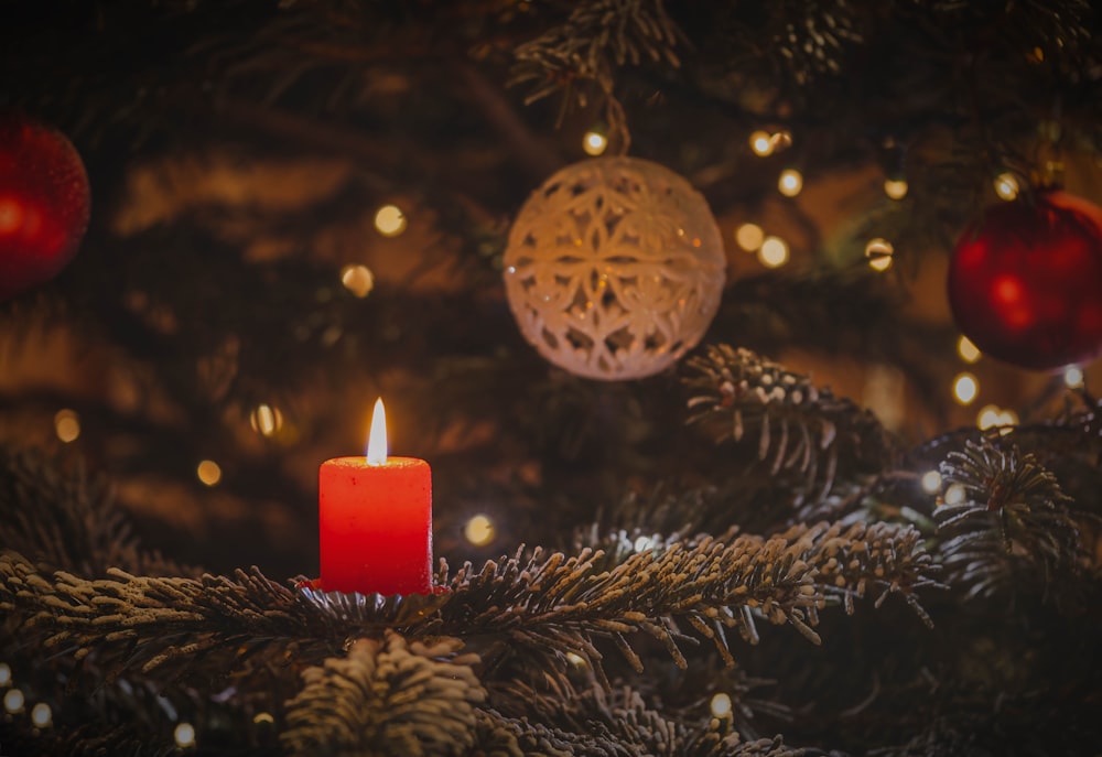 a lit candle sitting on top of a christmas tree