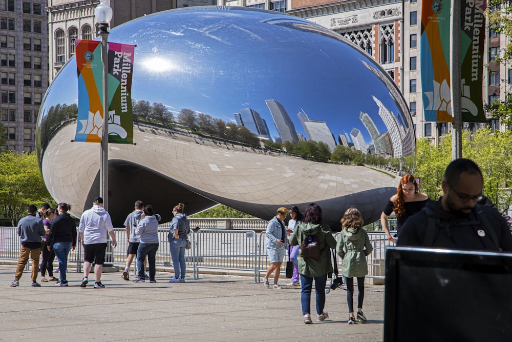 a group of people standing in front of a large metal object