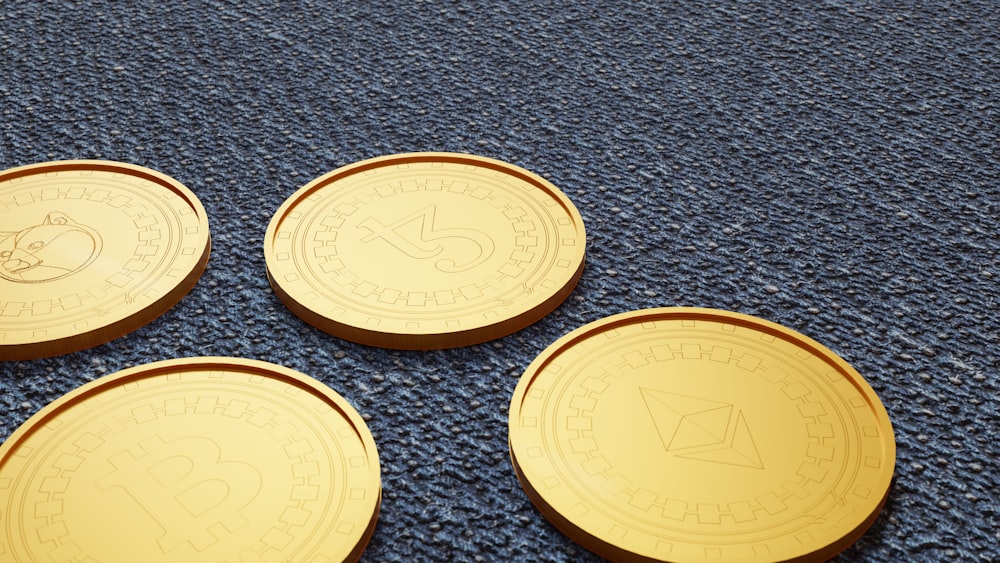 four gold tokens sitting on a blue carpet