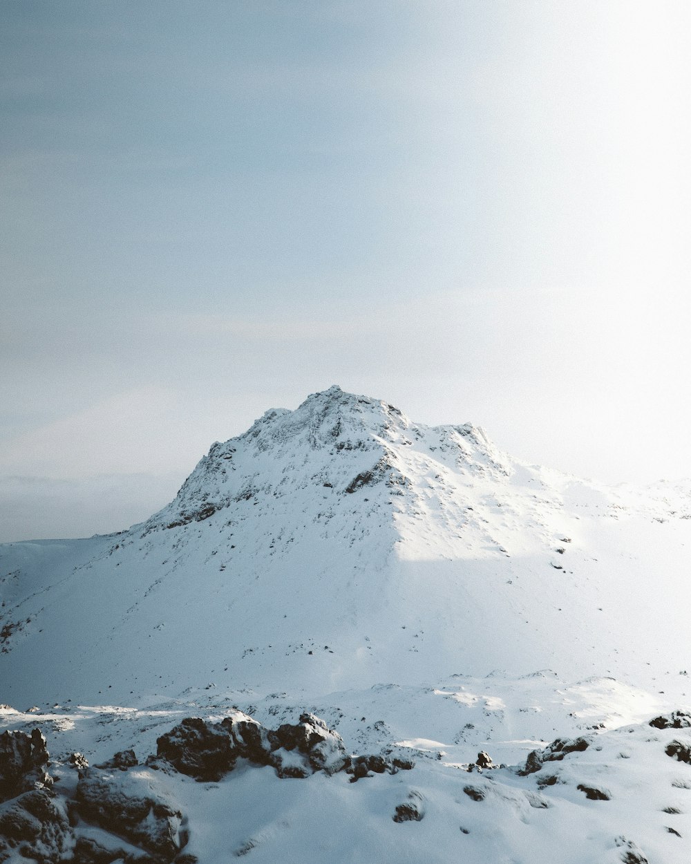 a mountain covered in snow under a blue sky