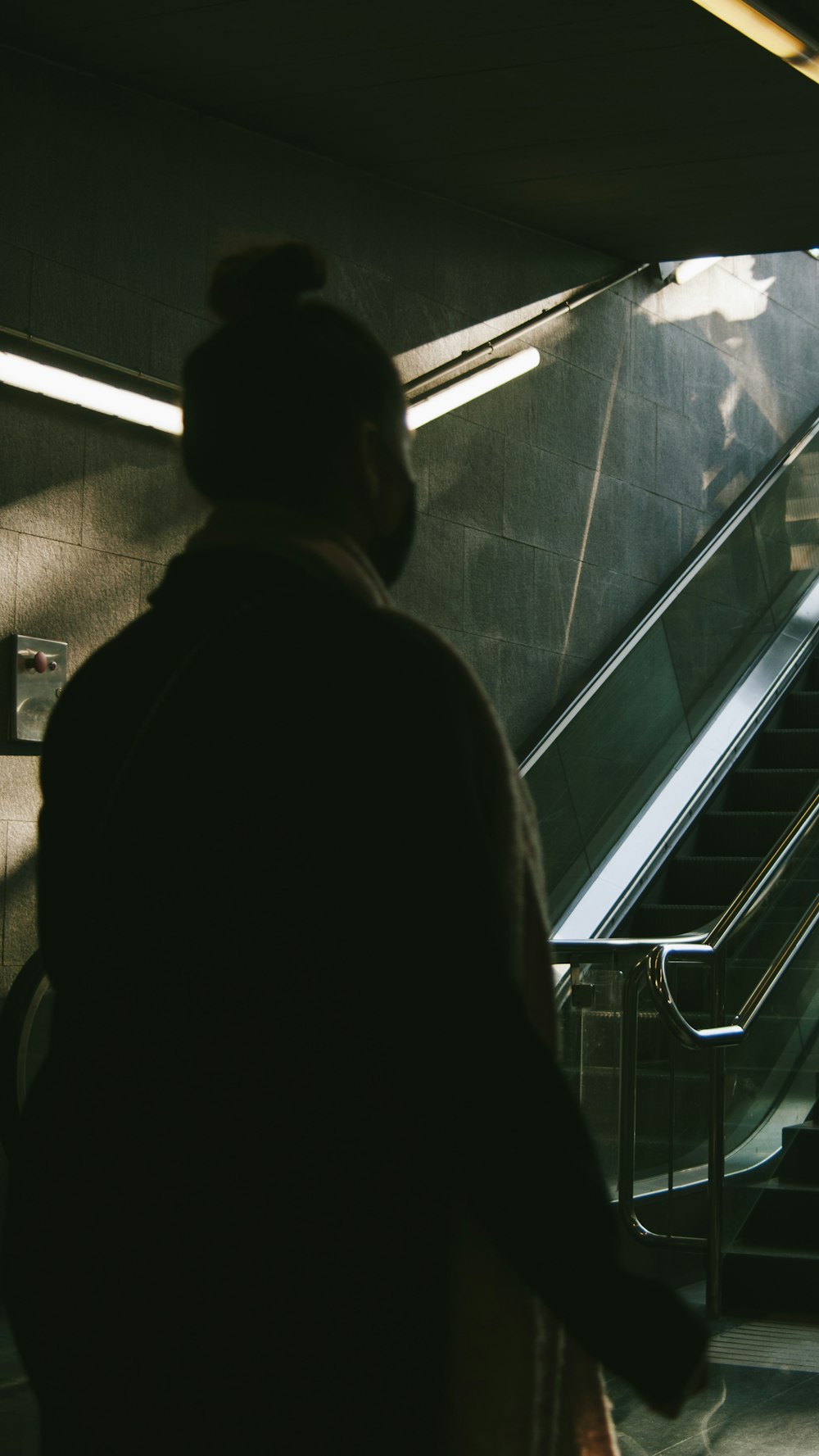 a man walking down an escalator next to an escalator