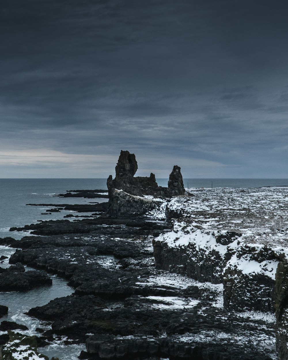 a large body of water near a rocky shore