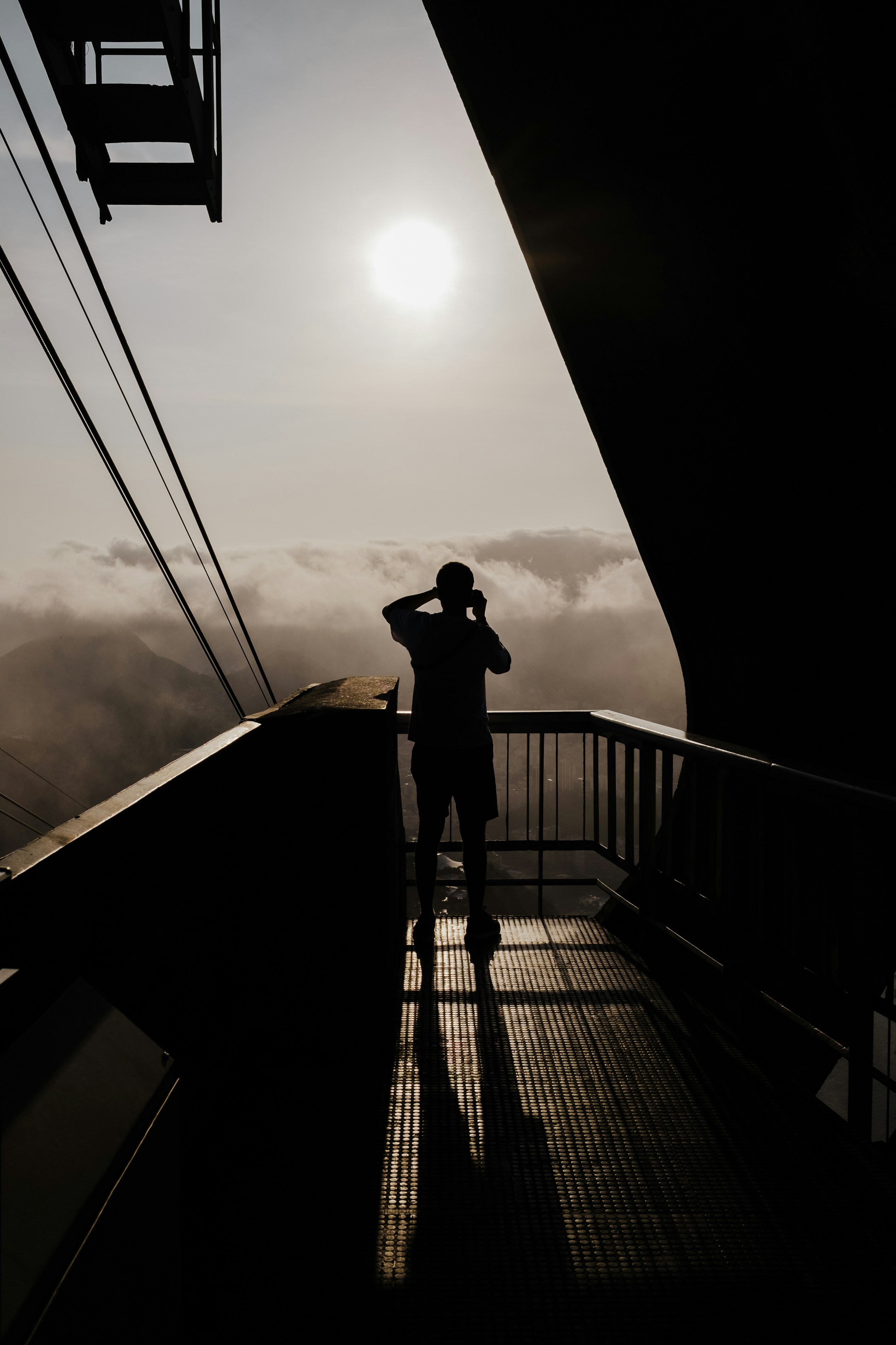 a man standing on top of a balcony next to a tall building