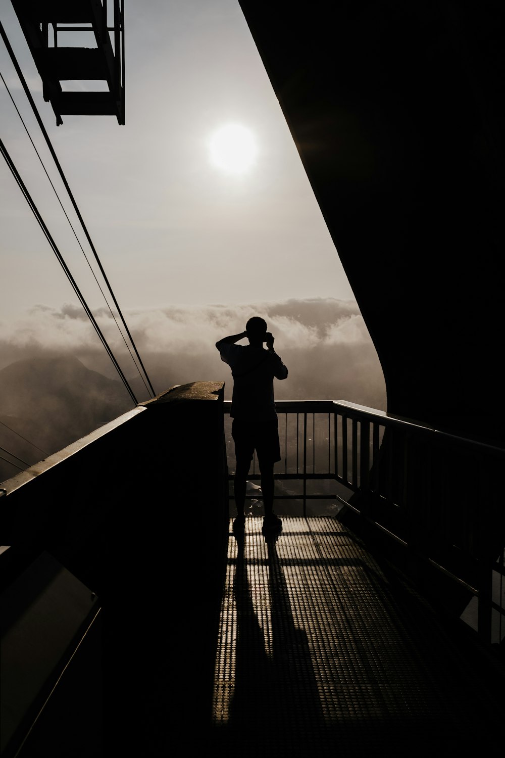 a man standing on top of a balcony next to a tall building