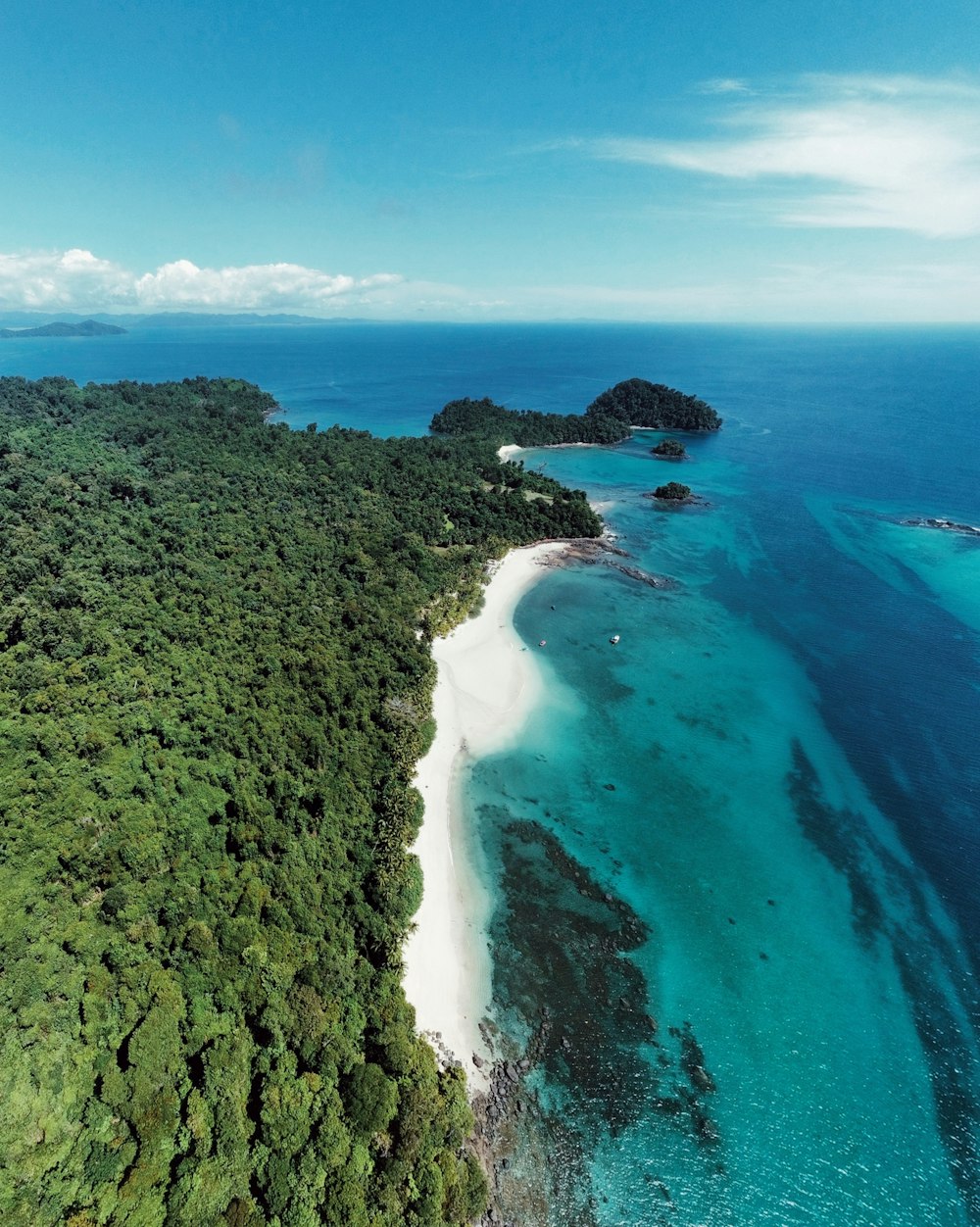 Una vista aérea de una isla tropical con una playa de arena blanca