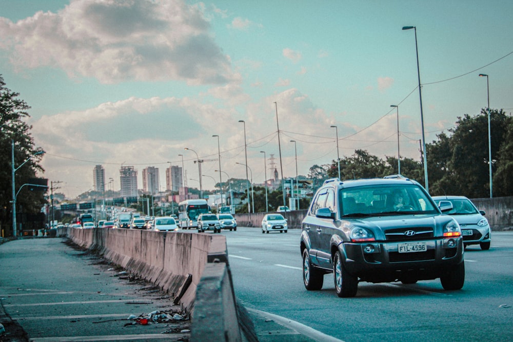 a blue truck driving down a street next to tall buildings