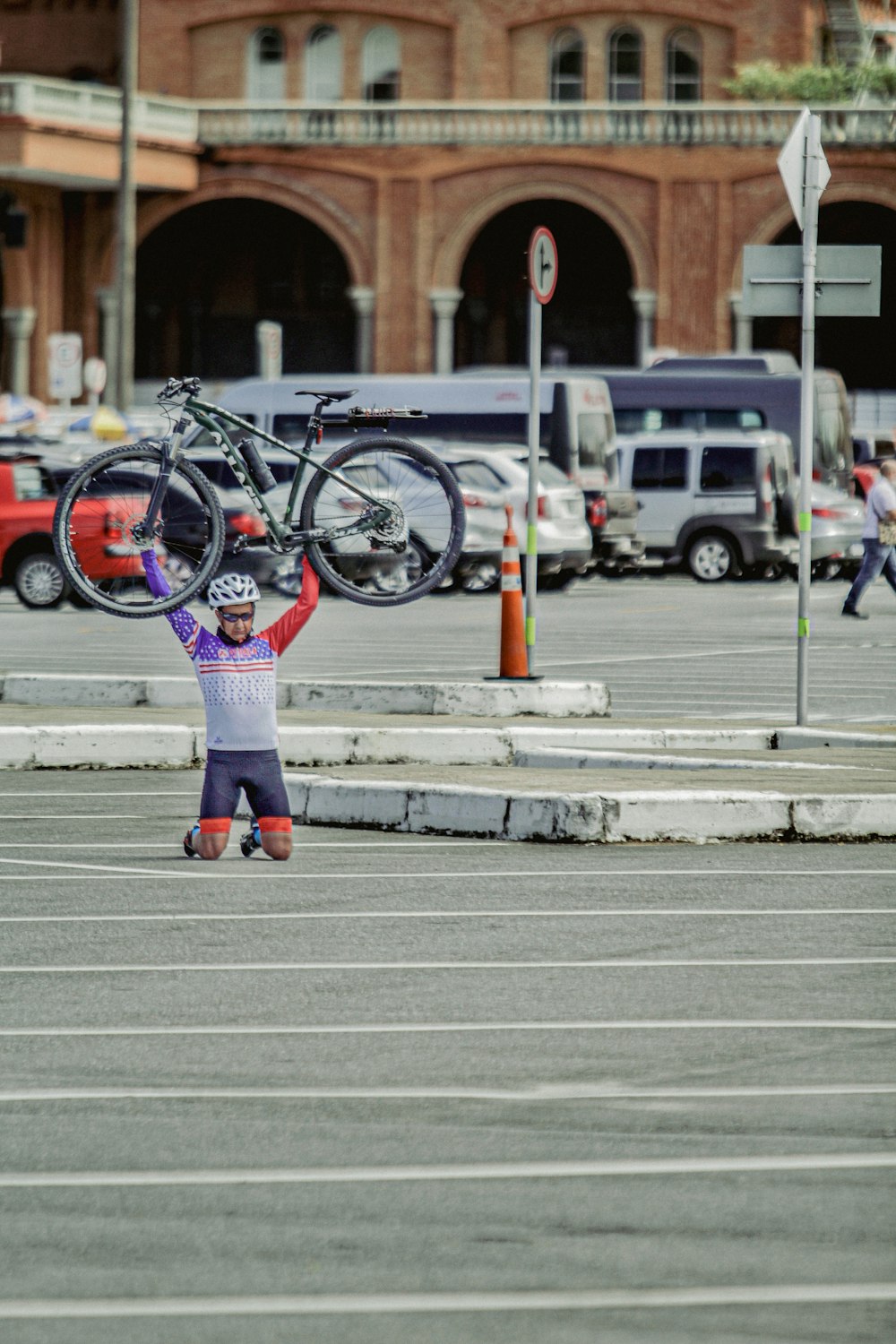 a little girl holding a bike on her shoulders