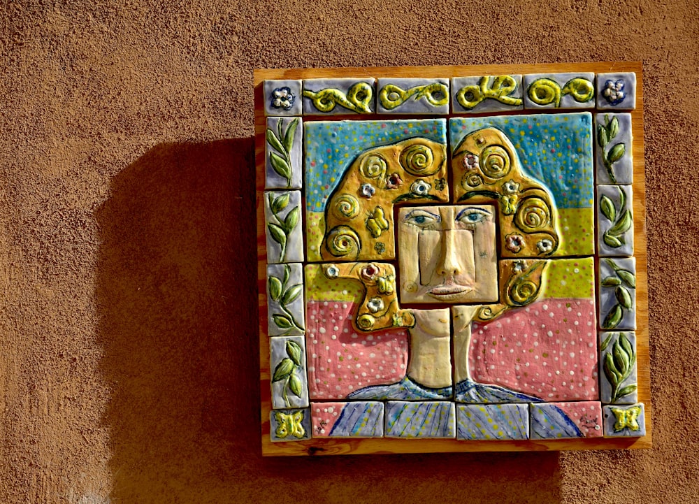 a colorful tile artwork of a woman's face on a wall